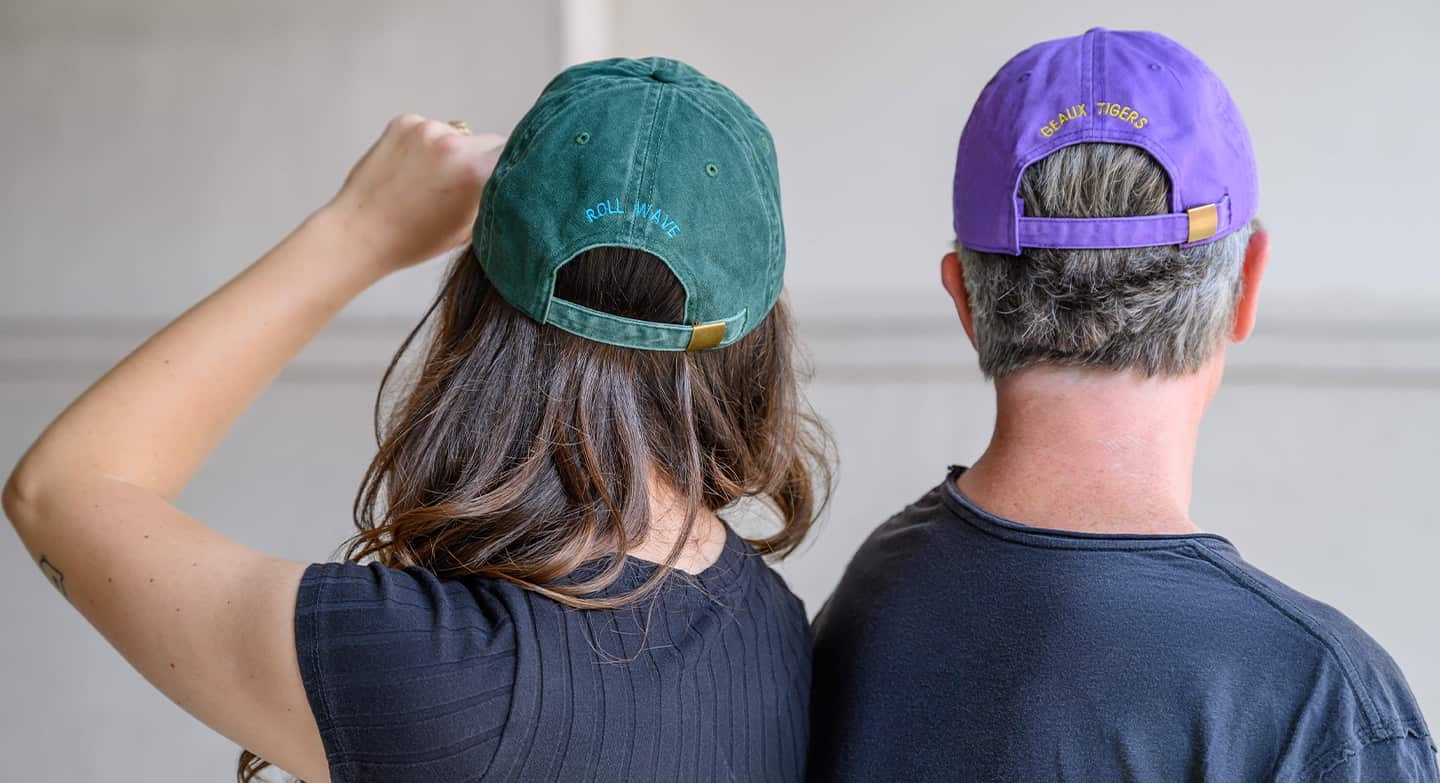 Man and woman showing back of hats.