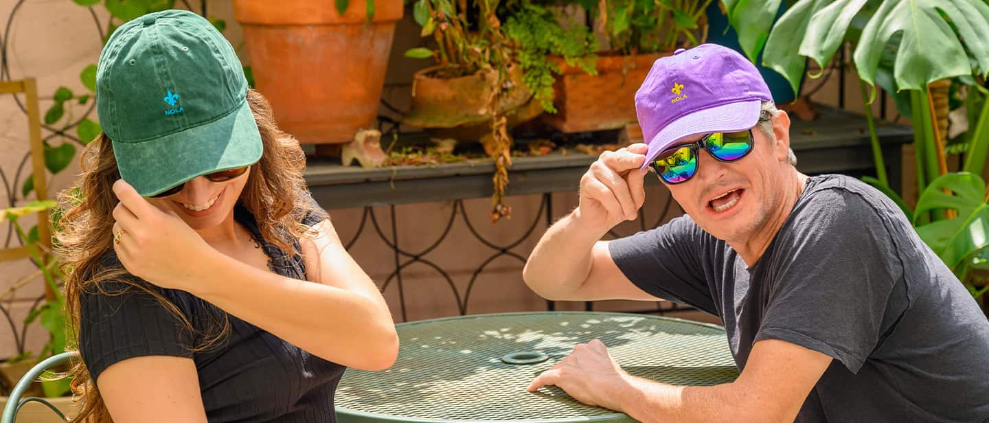 Man and woman touching their hats.