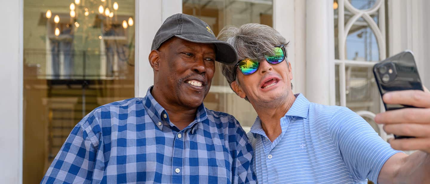 Two men posing for selfies.